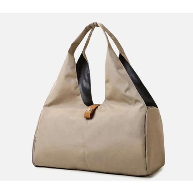 Stylish waterproof sports bag for women in beige and black, ideal for gym, yoga, and weekend getaways.